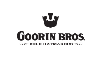 Schwarzer Text auf weißem Hintergrund lautet „Goorin Bros. Bold Hatmakers“ mit einem Emblem darüber, das an eine Burg mit drei Türmen erinnert.